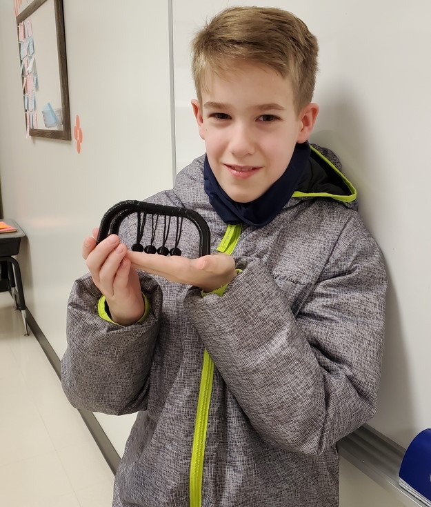 Student Jason McCollum holding Newton's Cradle he created on 3D printer.